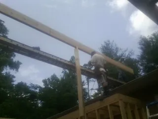 Carpenter setting a ridge beam over a new addition frame — Ice Dam Removal by Roofing Brothers in South Glastonbury