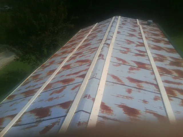 Rusted metal roof panels with new wood purlins before replacement — Storm Damage Roof Repair in South Glastonbury by Roofing Brothers